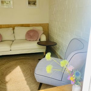 Knusse woonkamer met bank en stoel.