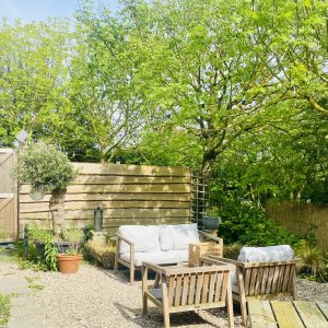 Zonnige tuin met meubels en planten